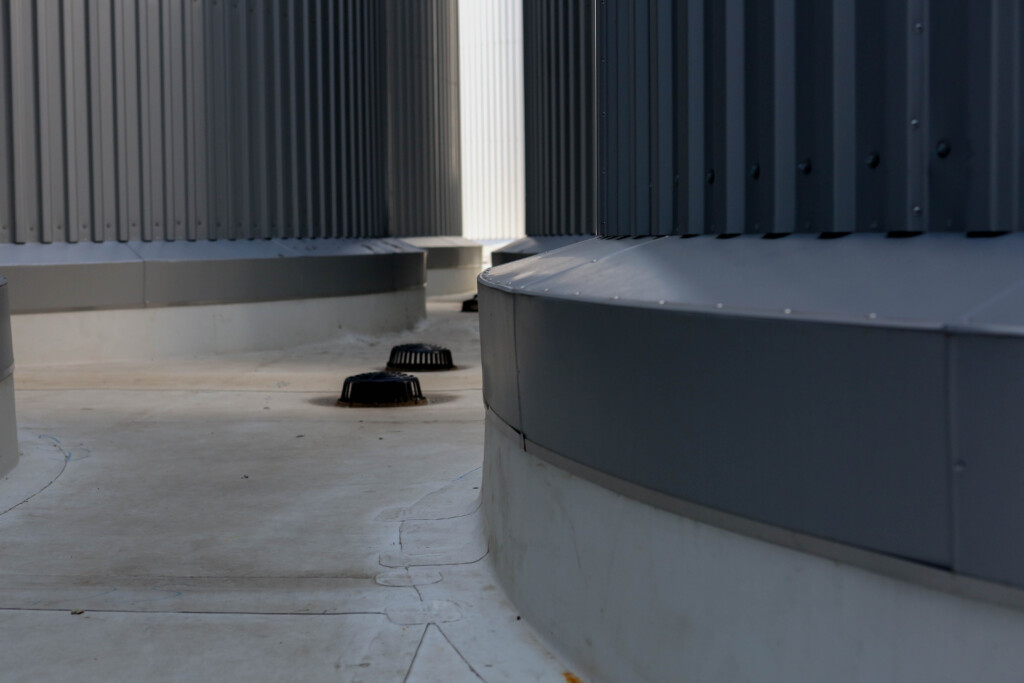 Gray industrial structure with circular vents and corrugated metal walls