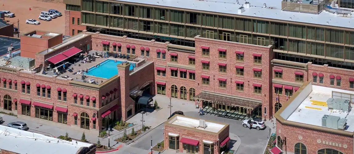 Aerial view of a hotel with rooftop pool.